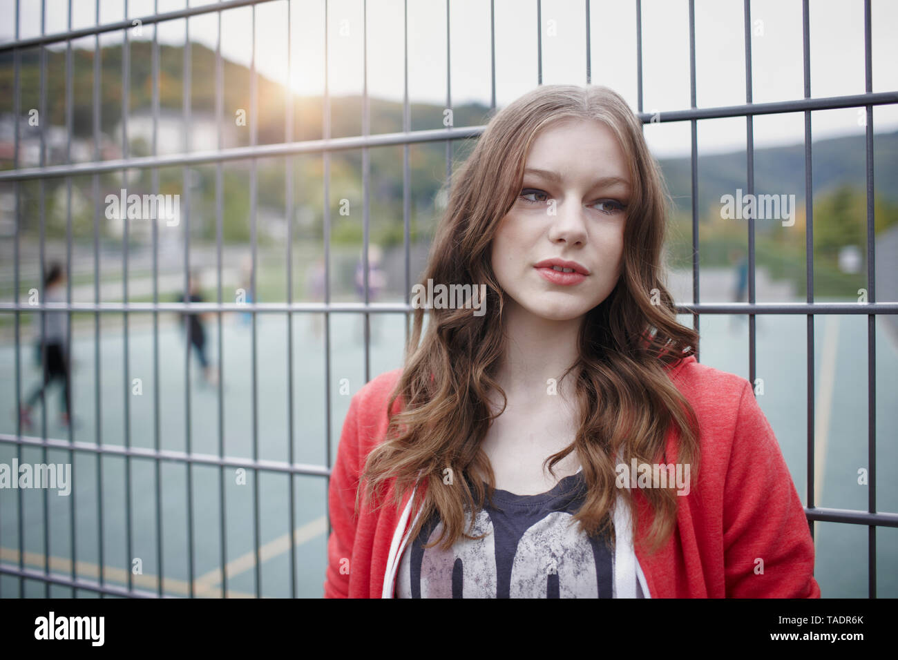 Portrait von teenage Mädchen an einem Zaun an einem Sportplatz Stockfoto