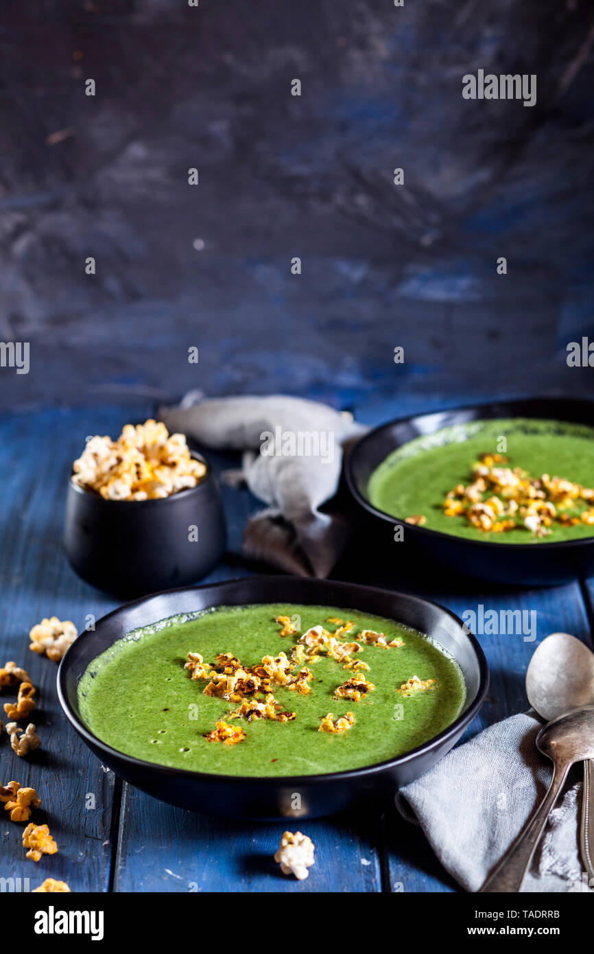 Vegane grüne Suppe mit Spinat, Lauch, Erbsen, Paprika Popcorn Stockfoto