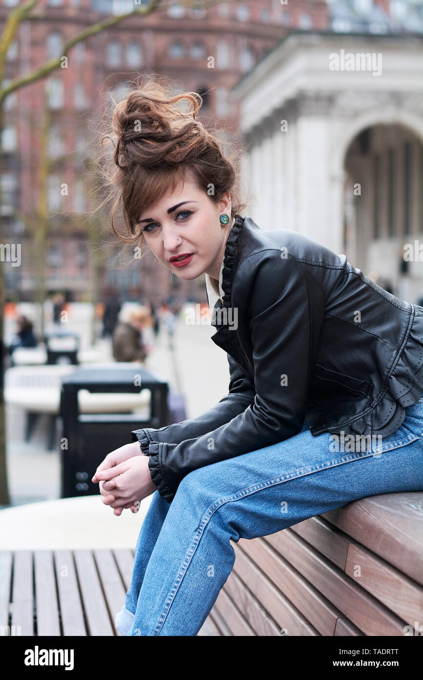 Junge Frau auf einer Bank in Manchester sitzen Stockfoto