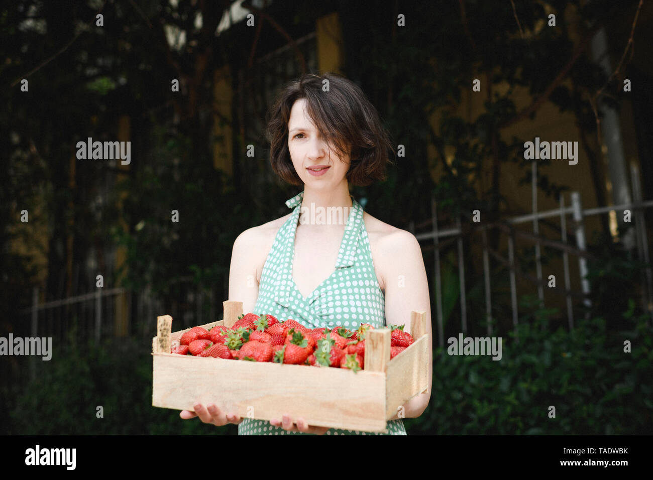 Portrait von Frau mit Kiste mit Erdbeeren Stockfoto