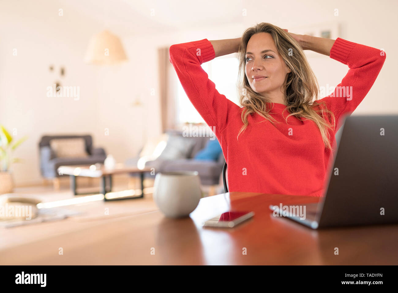 Frau am Esstisch zu Hause eine Pause von der Arbeit am Laptop Stockfoto