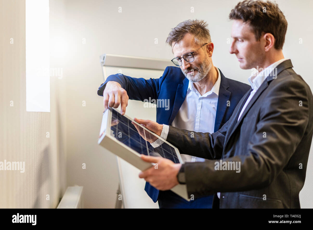 Zwei Geschäftsleute in Office mit Solarzelle diskutieren Stockfoto