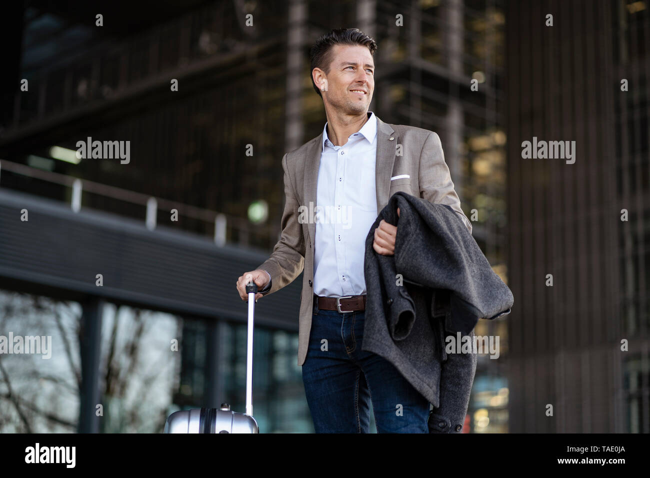 Geschäftsmann mit Koffer stehen im Freien Stockfoto