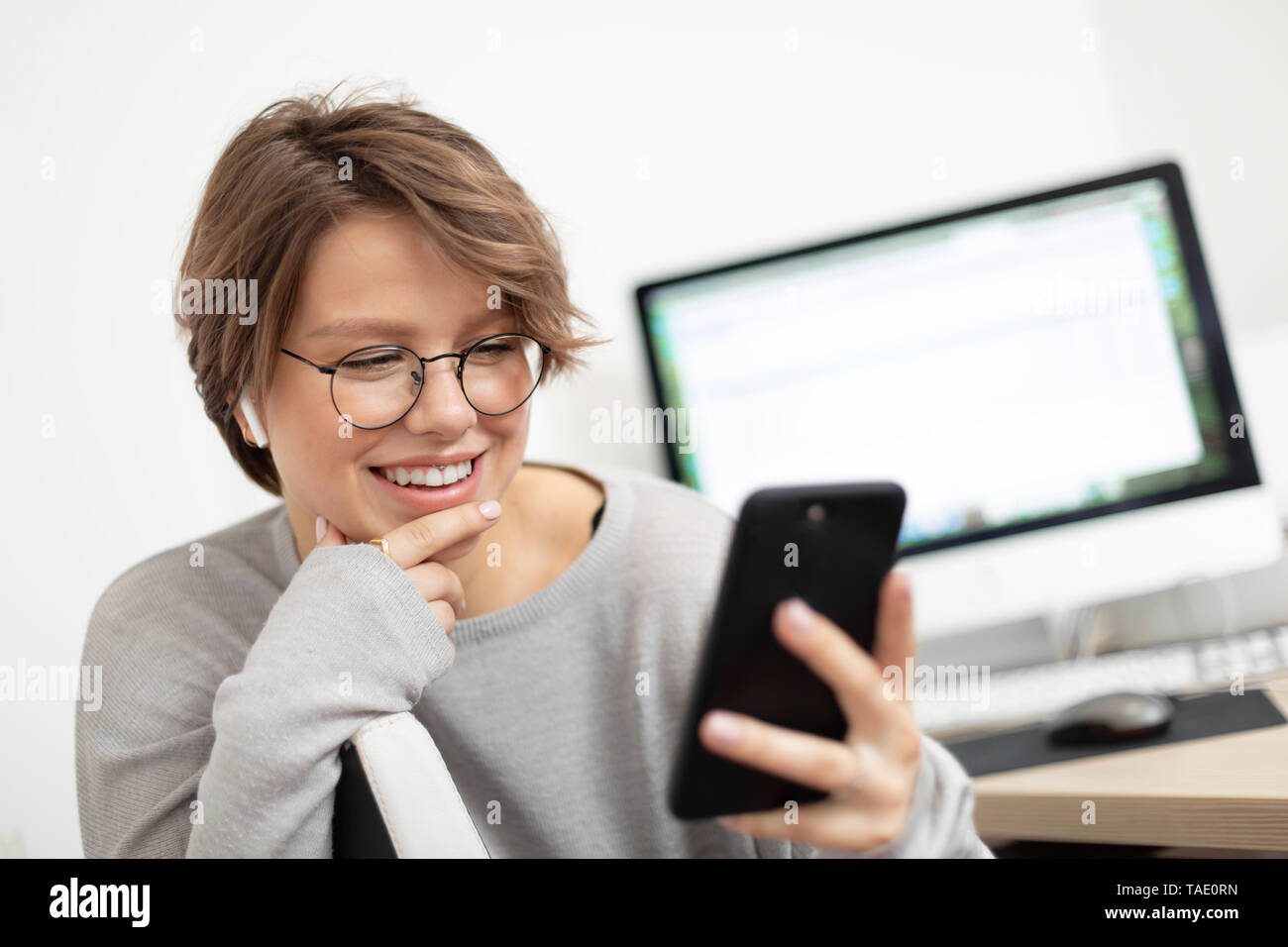 Junge Frau mit zu Hause smartphone, Arbeitsplatz Stockfoto