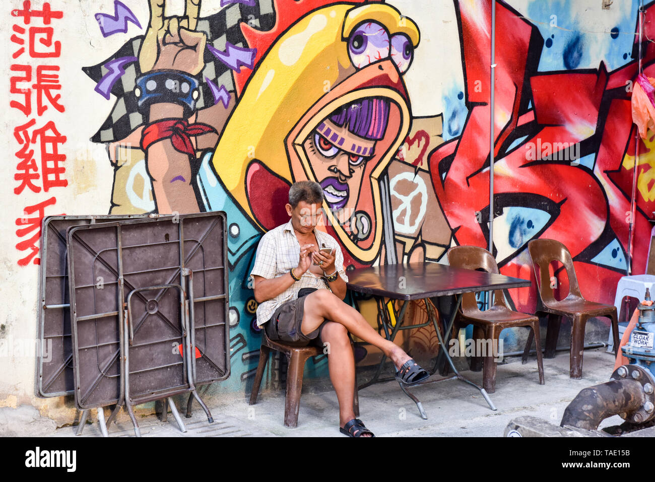 Man SMS auf seinem Mobiltelefon, Kuala Lumpur Stockfoto