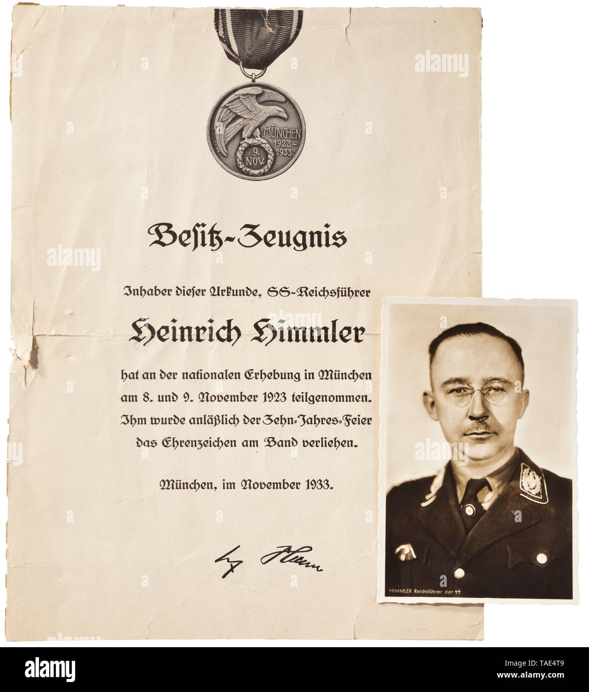 Heinrich Himmler - eine persönliche Auszeichnung Dokument für die Dekoration im Speicher vom 9. November 1923 (Blut) Dokument von cartonnage Papier, oben eine Abbildung des Blutes Um mit Band. Das Zentrum mit Text "Besitz-Zeugnis-Inhaber of this Urkunde, SS-Reichsführer Heinrich Himmler...' (Tr. "Besitz Zertifizierung - Träger dieses Dokument, SS-Reichsführer Heinrich Himmler ...'), November 1933 in München ausgestellt. Unten ist das faksimile Unterschrift von Adolf Hitler. Zentrale Falzmarken sowie edge Risse und Flecken, die Rückseite mit Papier bleibt von einer früheren, Editorial-Use - Nur Stockfoto