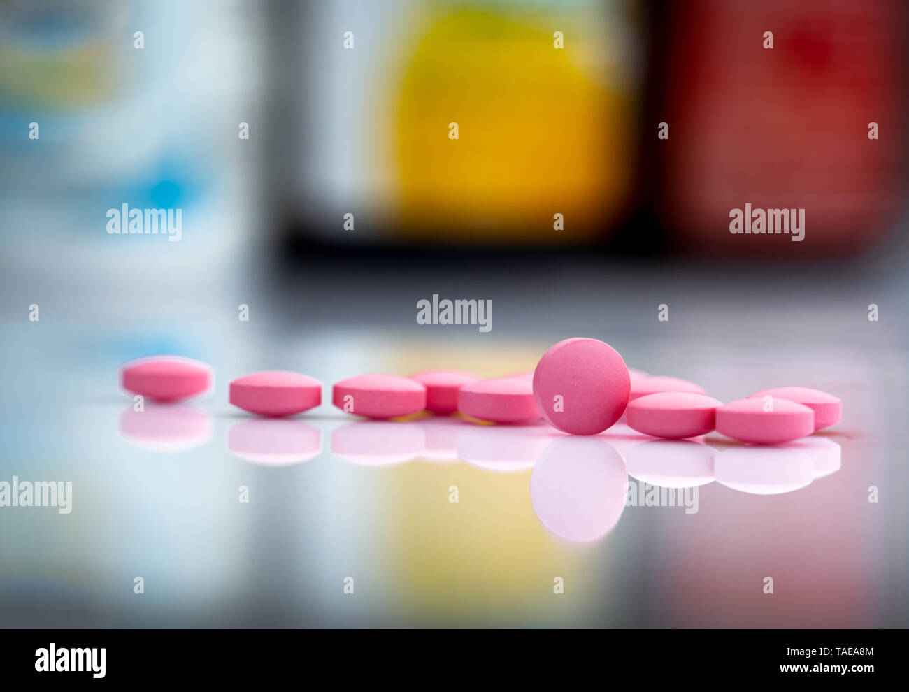 Rosa tabletten Pillen auf unscharfen Hintergrund der Droge Flasche in der Drogerie oder Apotheke im Krankenhaus. Pharmazeutische Industrie. Pharmazie Stockfoto