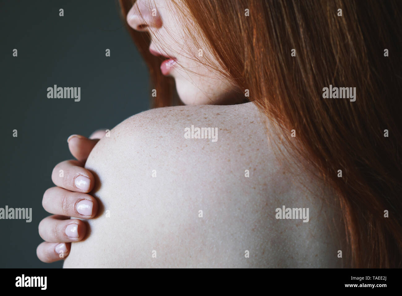 Junge Frau mit roten Haaren und Sommersprossen auf der nackten Schulter - Haut- und Körperpflege Konzept Stockfoto