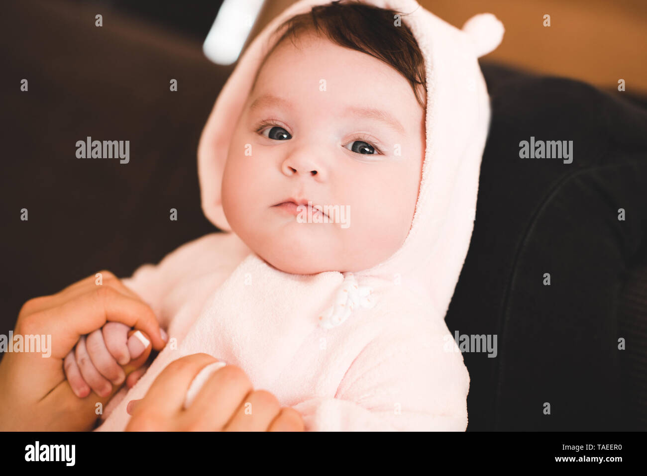 Lustige baby girl Holding Mutter hautnah. Mit Blick auf die Kamera. Die Mutterschaft. Mutterschaft. Stockfoto