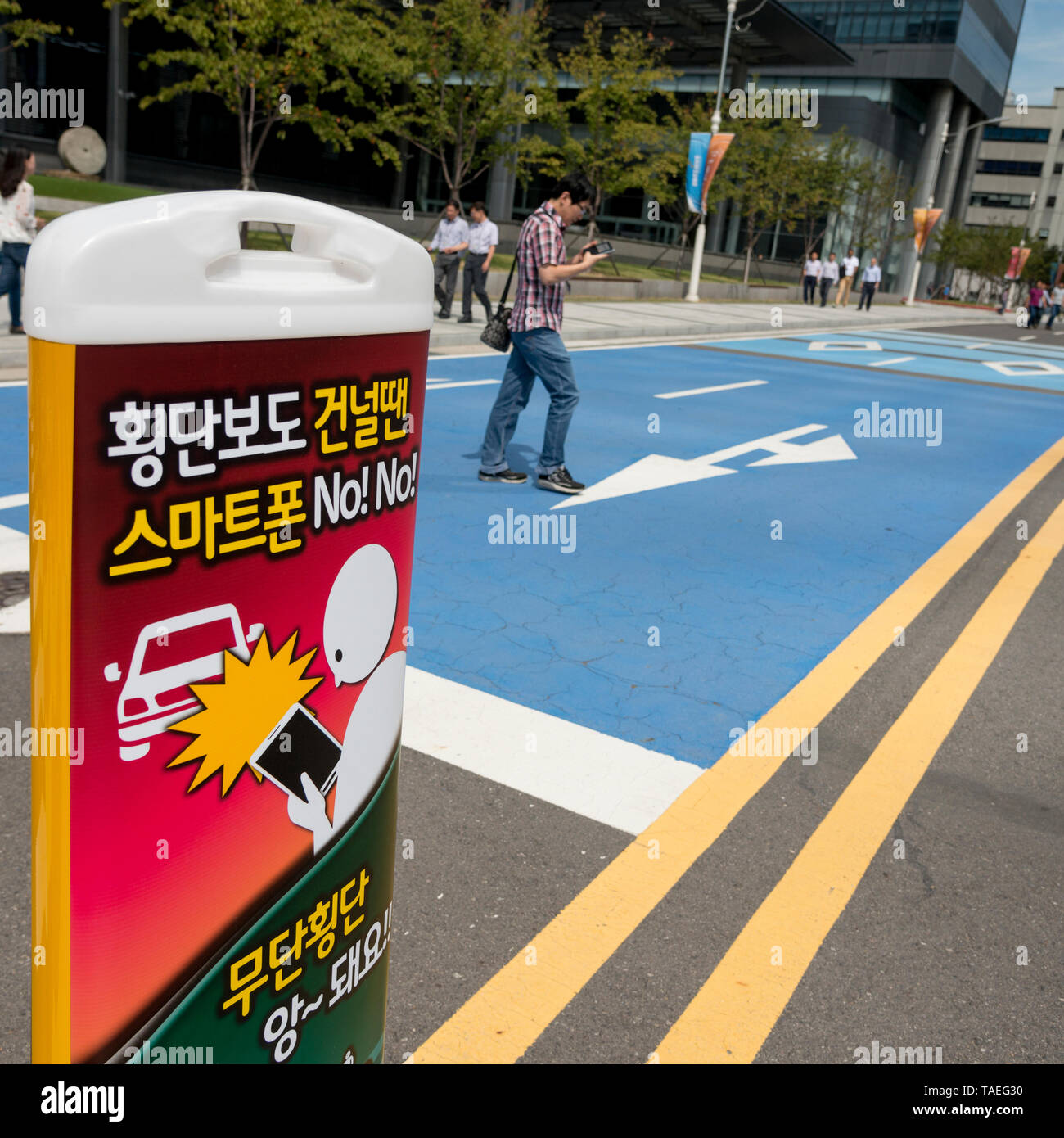 Nahaufnahme der Warnung Schild mit über Handy im Hintergrund Mann, Suwon, Südkorea Stockfoto