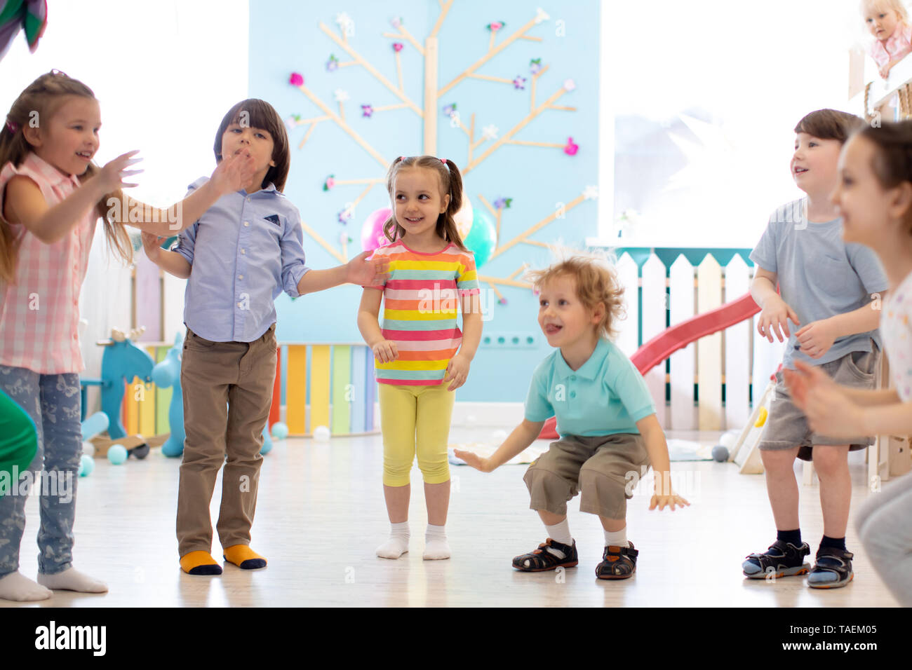 Gruppe der glückliche Kinder jumping Indoor. Kinder spielen zusammen Stockfoto
