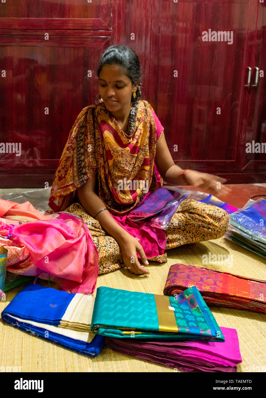 Vertikale Bildnis einer Dame verkaufen Seide Saris und Schals in einem Geschäft in Indien. Stockfoto