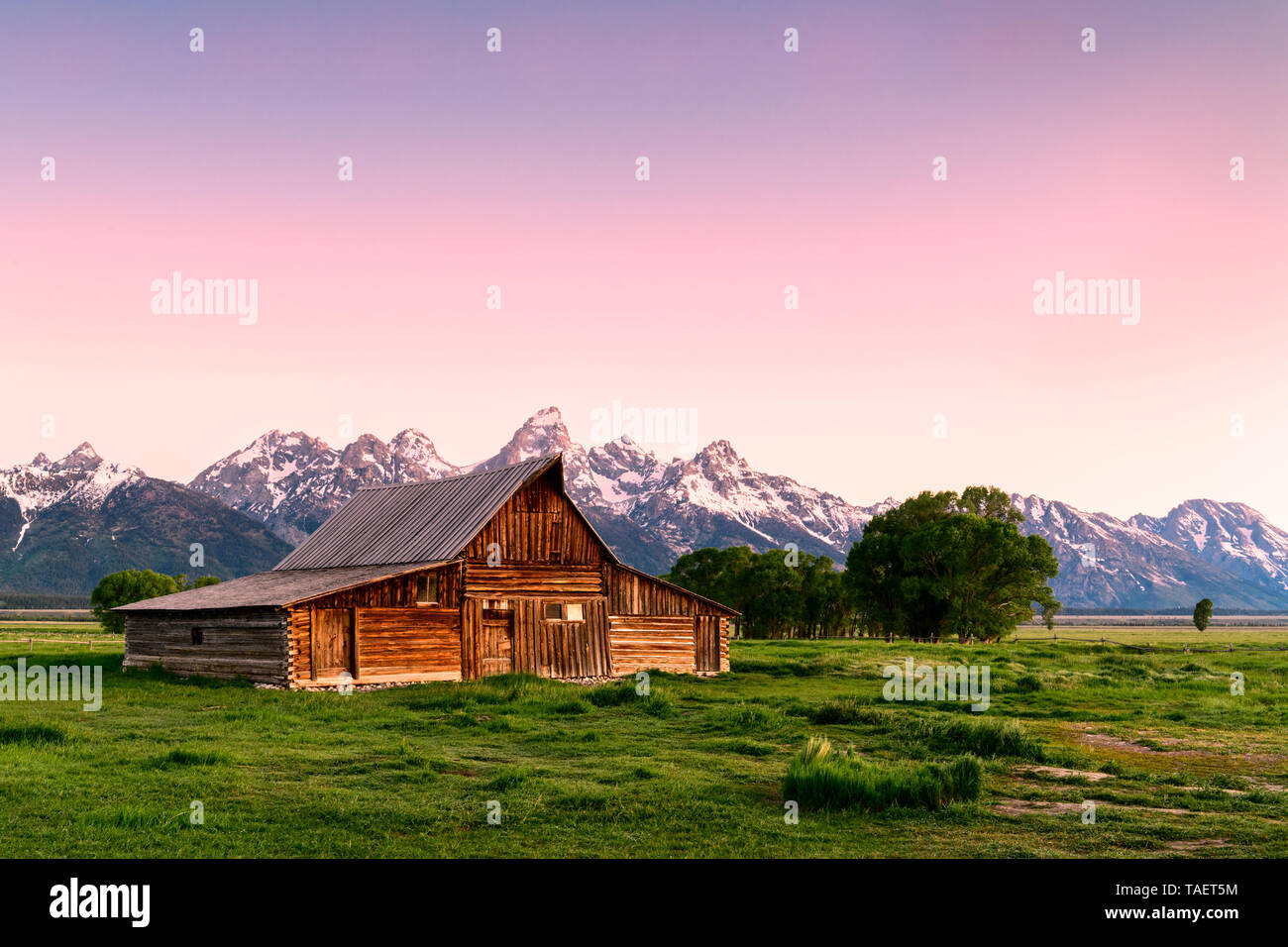 Eine alte Scheune entlang der Mormonen Zeile mit der Grand Tetons im Hintergrund in der Nähe von Jackson Hole, Wyoming USA. Stockfoto