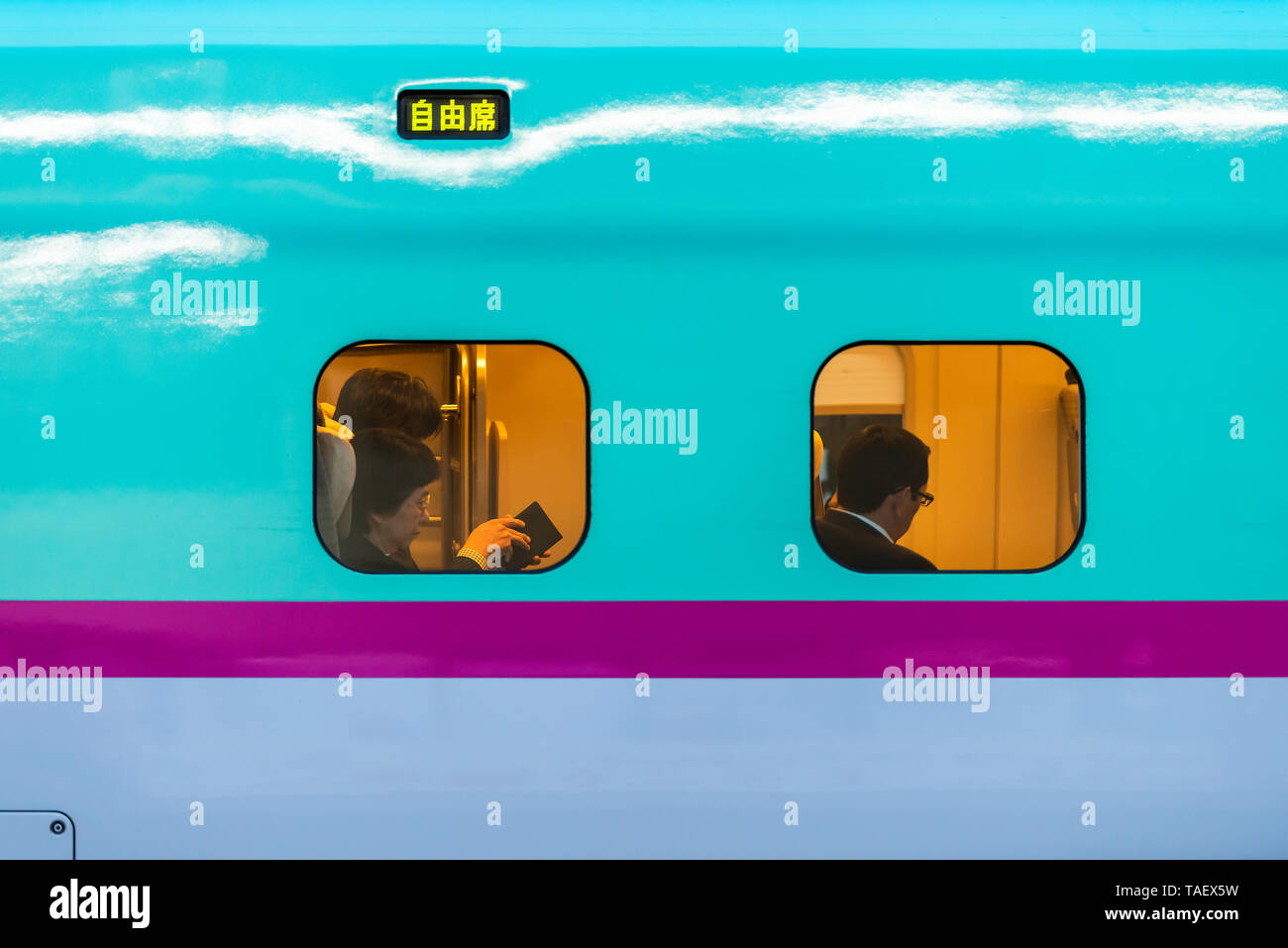 Tokio, Japan - April 5, 2019: Bahnhof Plattform mit Menschen sitzen Lesung im Shinkansen mit Geschäftsleuten salaryman Stockfoto