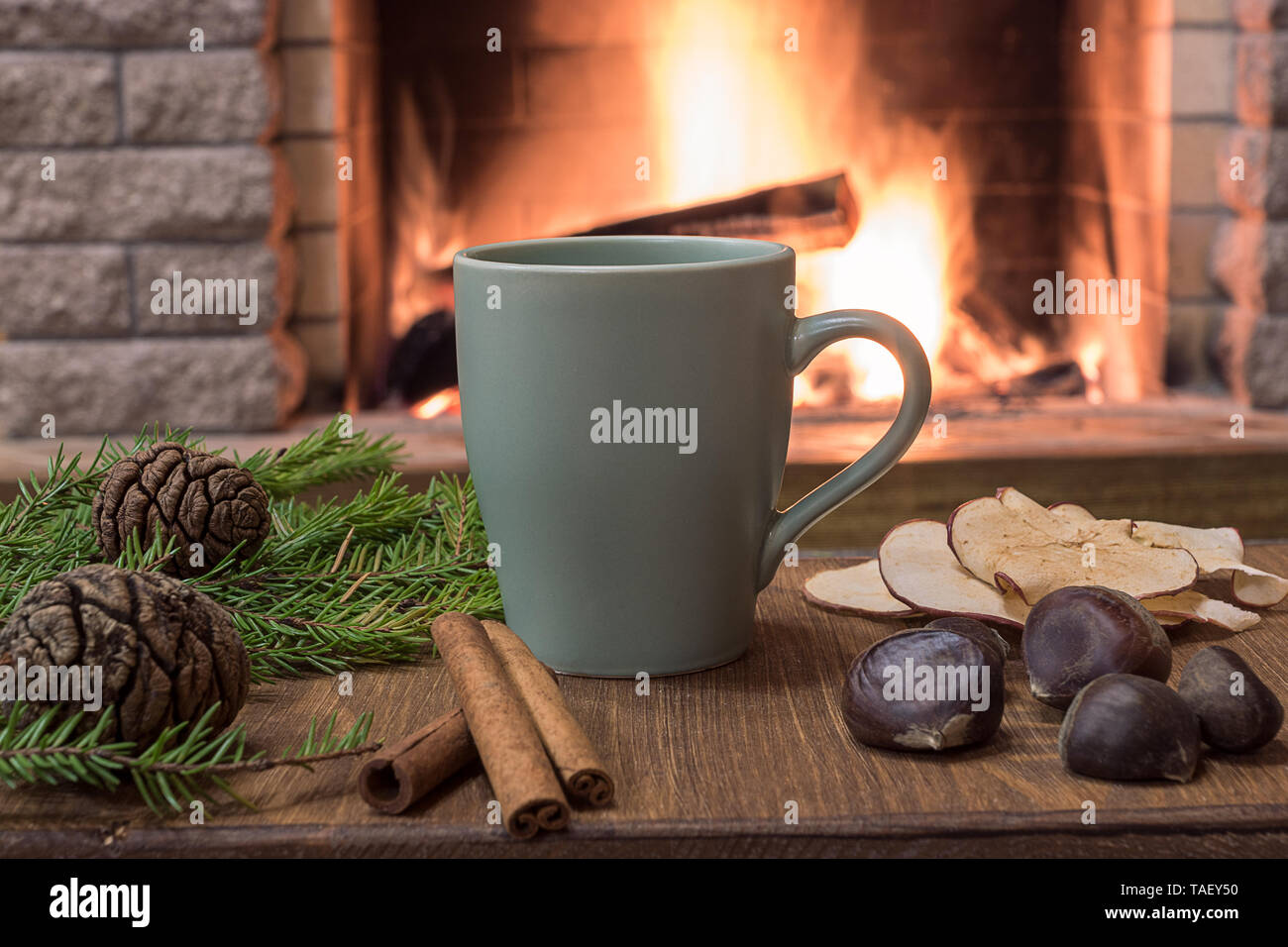 Becher mit heißem Tee, Wolle Schal und Kerzen in der Nähe der gemütlichen Kamin, im Landhaus, Winter Urlaub. Stockfoto