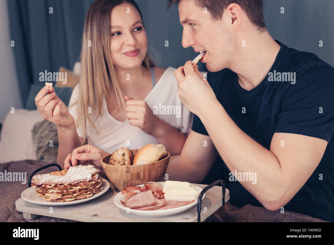 Junges Paar mit Frühstück im Bett Stockfoto