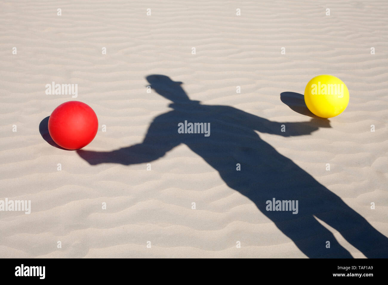 Schatten der Mann mit dem Hut und zwei Ballons in Sand Stockfoto