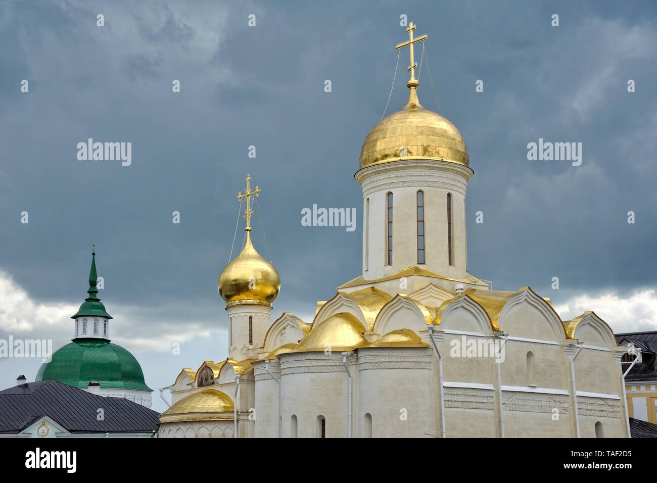 = goldenen Kuppeln der Dreifaltigkeitskathedrale gegen Dunkle Regenwolken= Blick von der Kathedrale der Heiligen Dreifaltigkeit - St. Segius Lavra auf dem schönen goldenen Stockfoto