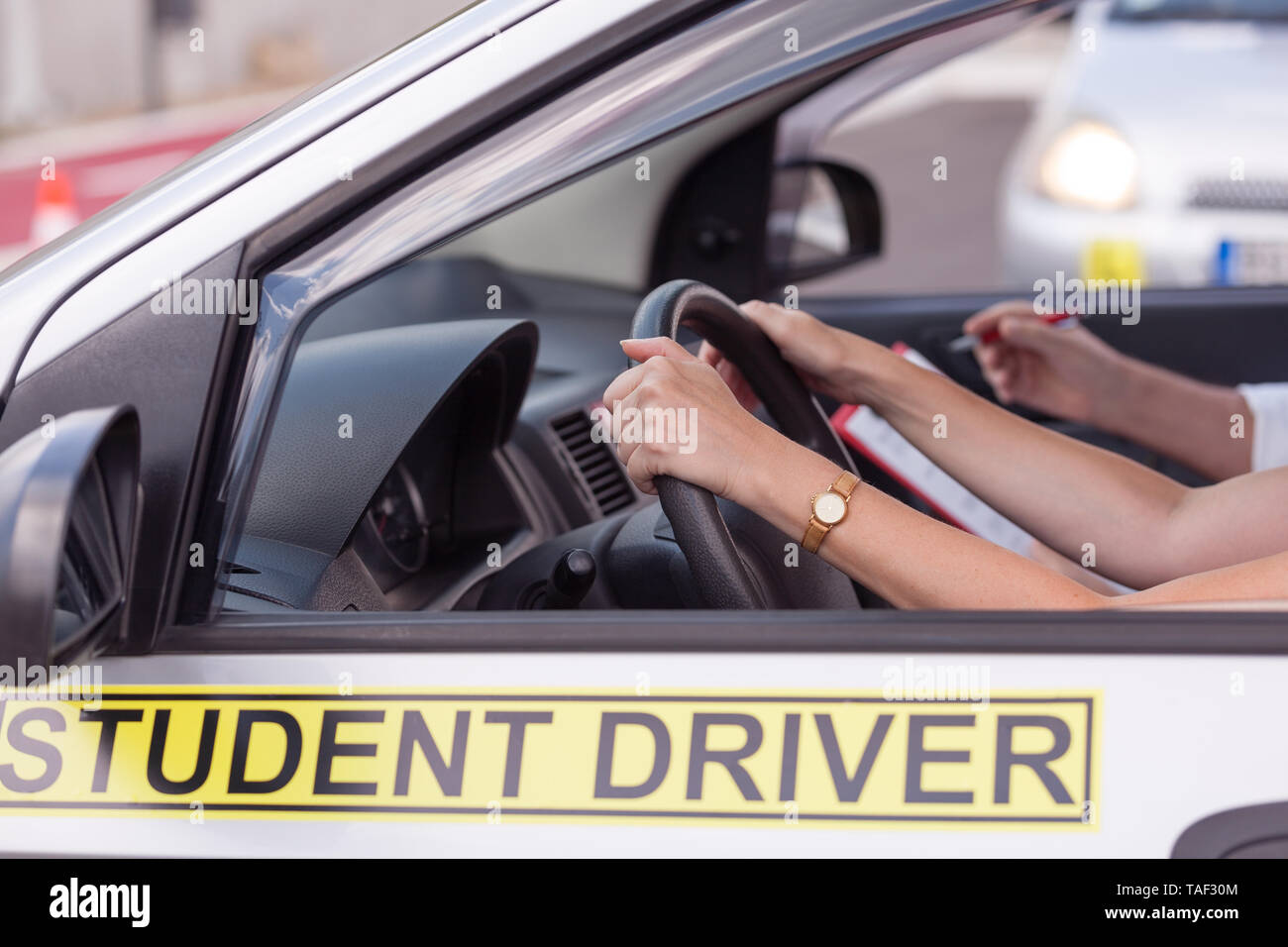 Student Treiber, mit den Händen am Lenkrad, lernen Auto mit Instruktor zu fahren. Fahrschule detail Stockfoto