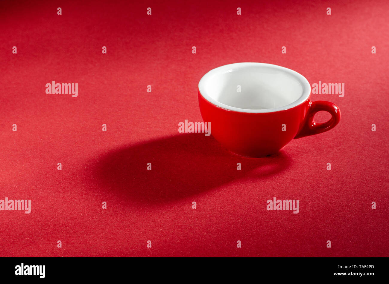 Rot Tasse auf einem roten Hintergrund für Ihr Design. Werbefoto. Stockfoto