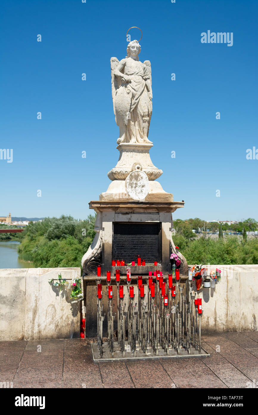 Religiöse Statue mit einem Halo und rote Kerzen unten wieder hergestellt und gestärkt römische Brücke, Cordoba, Region Andalusien, Spanien Stockfoto