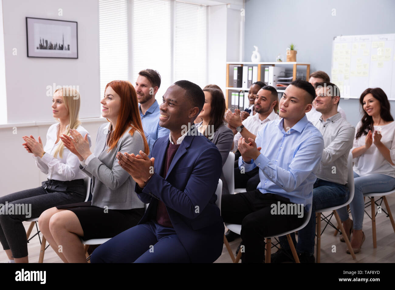 Publikum sitzen auf Stuhl in der Zeile applaudieren Redner nach dem Konferenz Präsentation Stockfoto