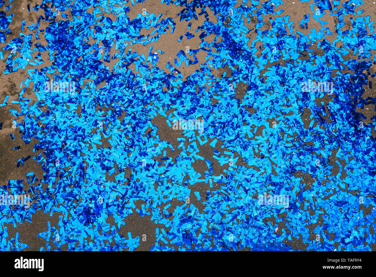 Blau Konfetti auf Asphalt nach einem Urlaub, Party, Karneval. Dekorationen für eine Geburtstagsfeier oder Einladung. Konfetti, Stockfoto