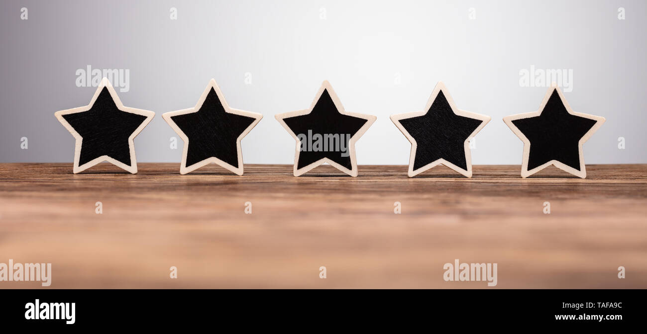 In der Nähe von Fünf Sternen Symbol in der Zeile auf hölzernen Schreibtisch Stockfoto
