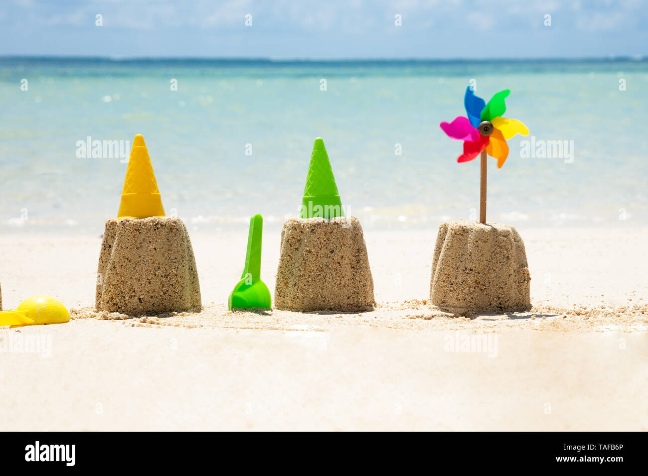 Spielzeug mit bunten Windrad Vor Meer auf Sand am Strand Stockfoto