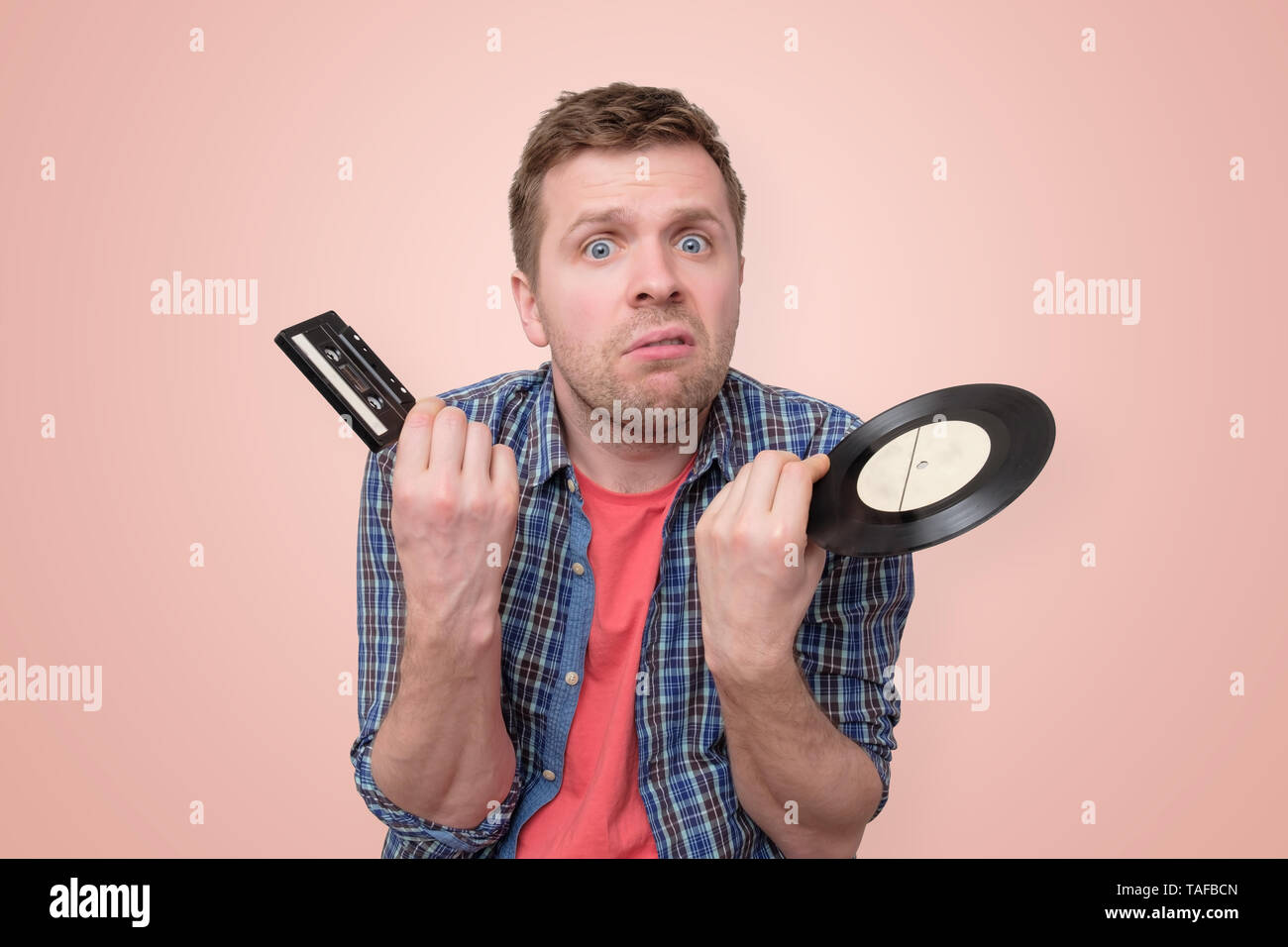 Mann mit Kassette und alten retro Vinyl verwirrt und ratlos Stockfoto