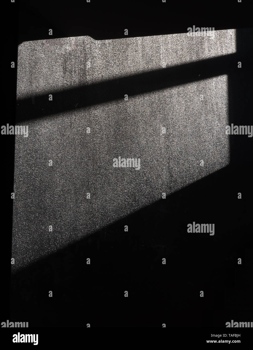 Ein schwarzes Fenster Schatten auf die graue Betonwand Stockfoto