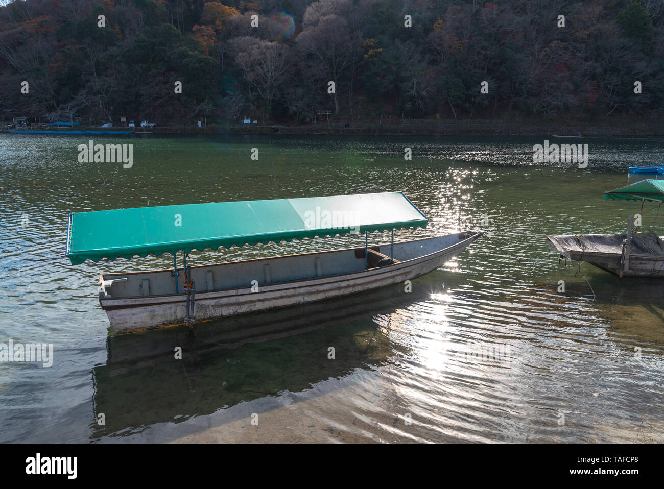 Boot an Hozu-gawa Fluss und Togetsu-kyo Brücke mit bunten Wald Berg Hintergrund in Arashiyama, Kyoto, Japan. Arashiyama ist ein National Desig Stockfoto