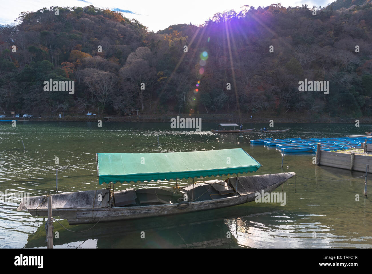 Boot an Hozu-gawa Fluss und Togetsu-kyo Brücke mit bunten Wald Berg Hintergrund in Arashiyama, Kyoto, Japan. Arashiyama ist ein National Desig Stockfoto
