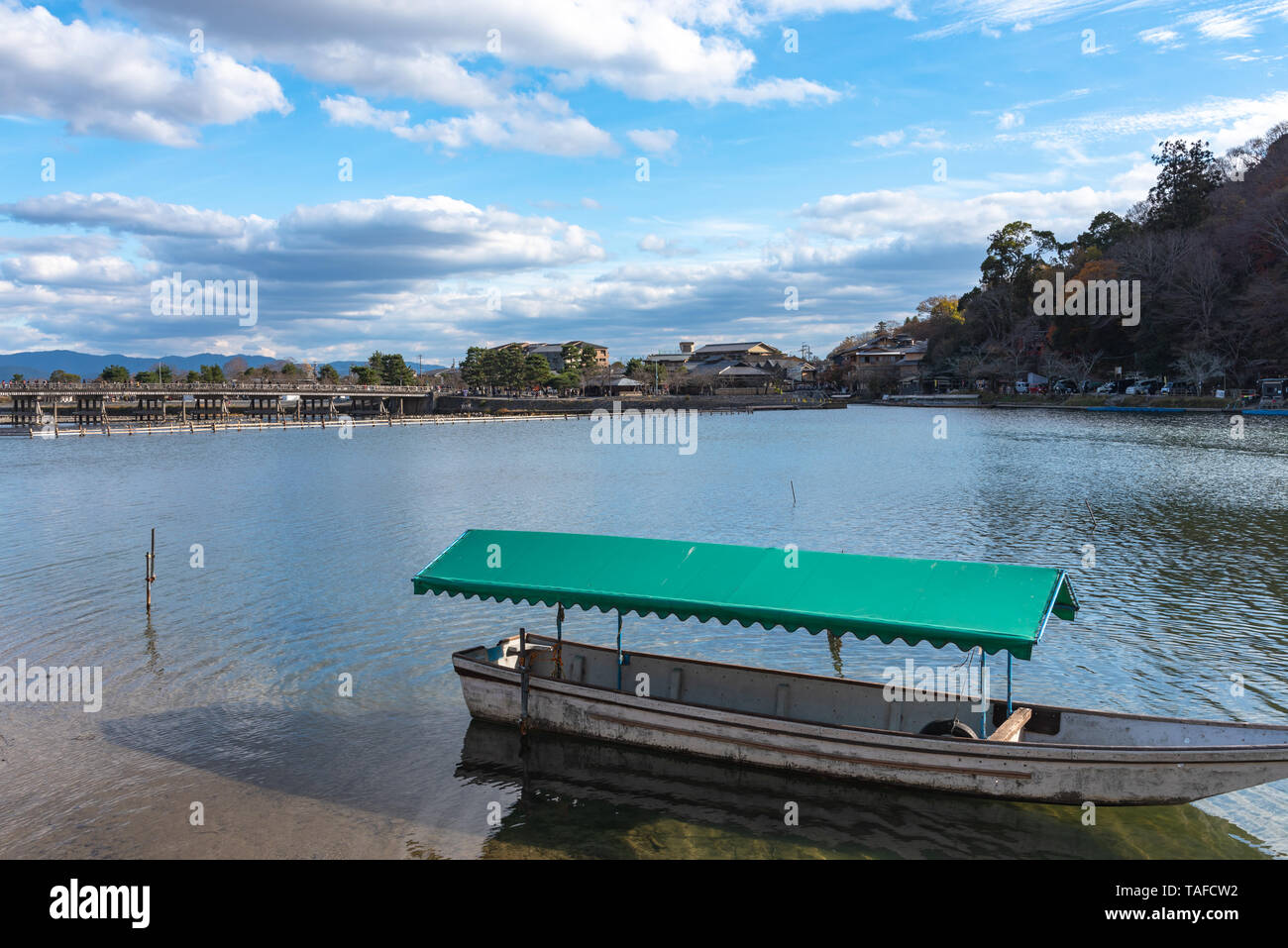 Boot an Hozu-gawa Fluss und Togetsu-kyo Brücke mit bunten Wald Berg Hintergrund in Arashiyama, Kyoto, Japan. Arashiyama ist ein National Desig Stockfoto