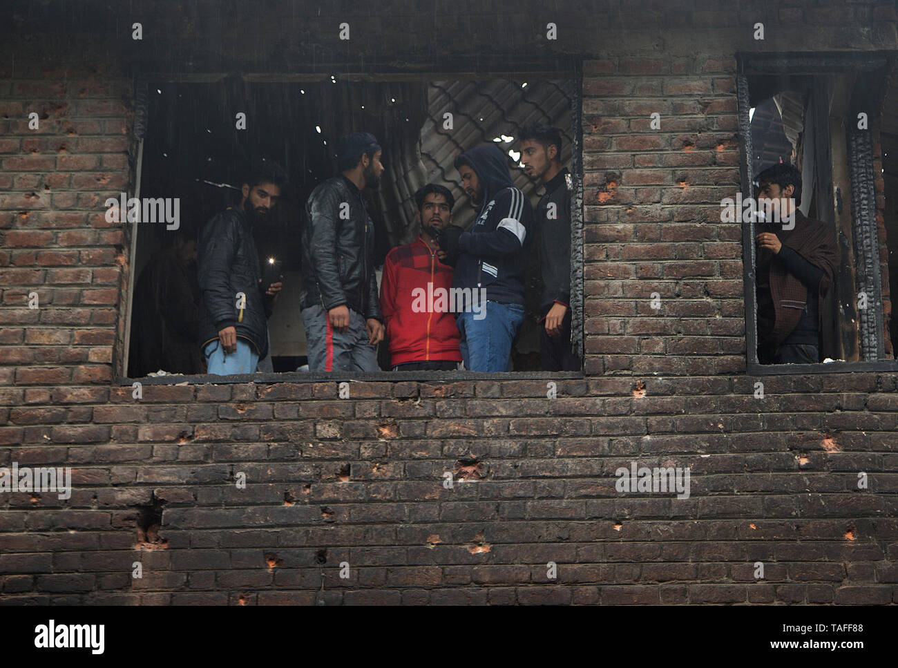 Srinagar, Indisch kontrollierten Teil Kaschmirs. 24. Mai, 2019. Menschen ein Haus in eine Schießerei beschädigt im Village Dadsara der Zentralen in Pulwama Bezirk, etwa 39 km südlich von Srinagar Stadt prüfen, der Sommer Hauptstadt von Indien kontrollierten Teil Kaschmirs, 24. Mai 2019. Eine militante Commander und Leiter der al-Qaida affiliate Ansar Gazwatul Hind - Zakir Musa war Donnerstag Abend in eine Schießerei mit den Streitkräften der Regierung in unruhigen Indischen getötet - Kaschmir gesteuert, sagte die Polizei. Credit: Javed Dar/Xinhua/Alamy leben Nachrichten Stockfoto