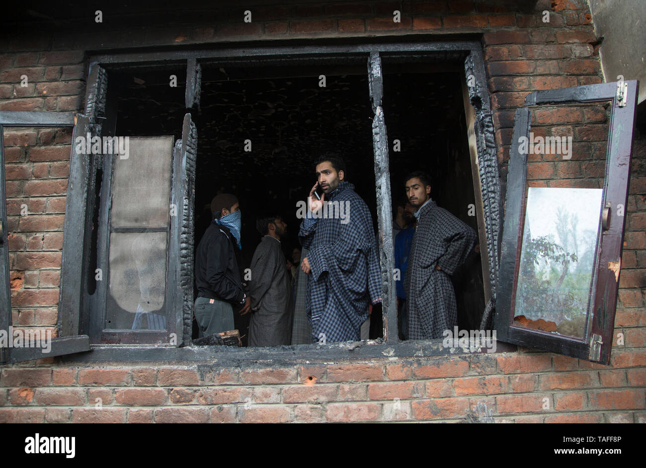 Srinagar, Indisch kontrollierten Teil Kaschmirs. 24. Mai, 2019. Menschen ein Haus in eine Schießerei beschädigt im Village Dadsara der Zentralen in Pulwama Bezirk, etwa 39 km südlich von Srinagar Stadt prüfen, der Sommer Hauptstadt von Indien kontrollierten Teil Kaschmirs, 24. Mai 2019. Eine militante Commander und Leiter der al-Qaida affiliate Ansar Gazwatul Hind - Zakir Musa war Donnerstag Abend in eine Schießerei mit den Streitkräften der Regierung in unruhigen Indischen getötet - Kaschmir gesteuert, sagte die Polizei. Credit: Javed Dar/Xinhua/Alamy leben Nachrichten Stockfoto