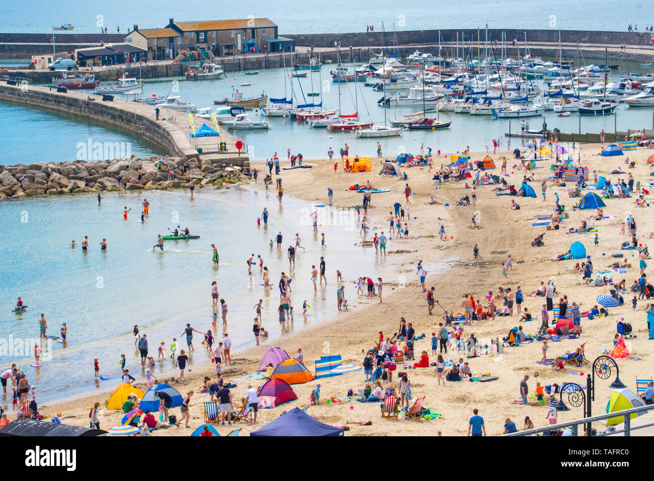 Lyme Regis, Dorset, Großbritannien. 25. Mai 2019. UK Wetter: Massen von Touristen und Besucher in Scharen zu den Strand in Lyme Regis in der heißen Sonne aalen als Küstenstadt am heißesten Tag des Jahres so weit brutzelt. Samstag ist der sonnigste Tag des späten May Bank Holiday Wochenende zu sein. Credit: Celia McMahon/Alamy Leben Nachrichten. Credit: Celia McMahon/Alamy leben Nachrichten Stockfoto