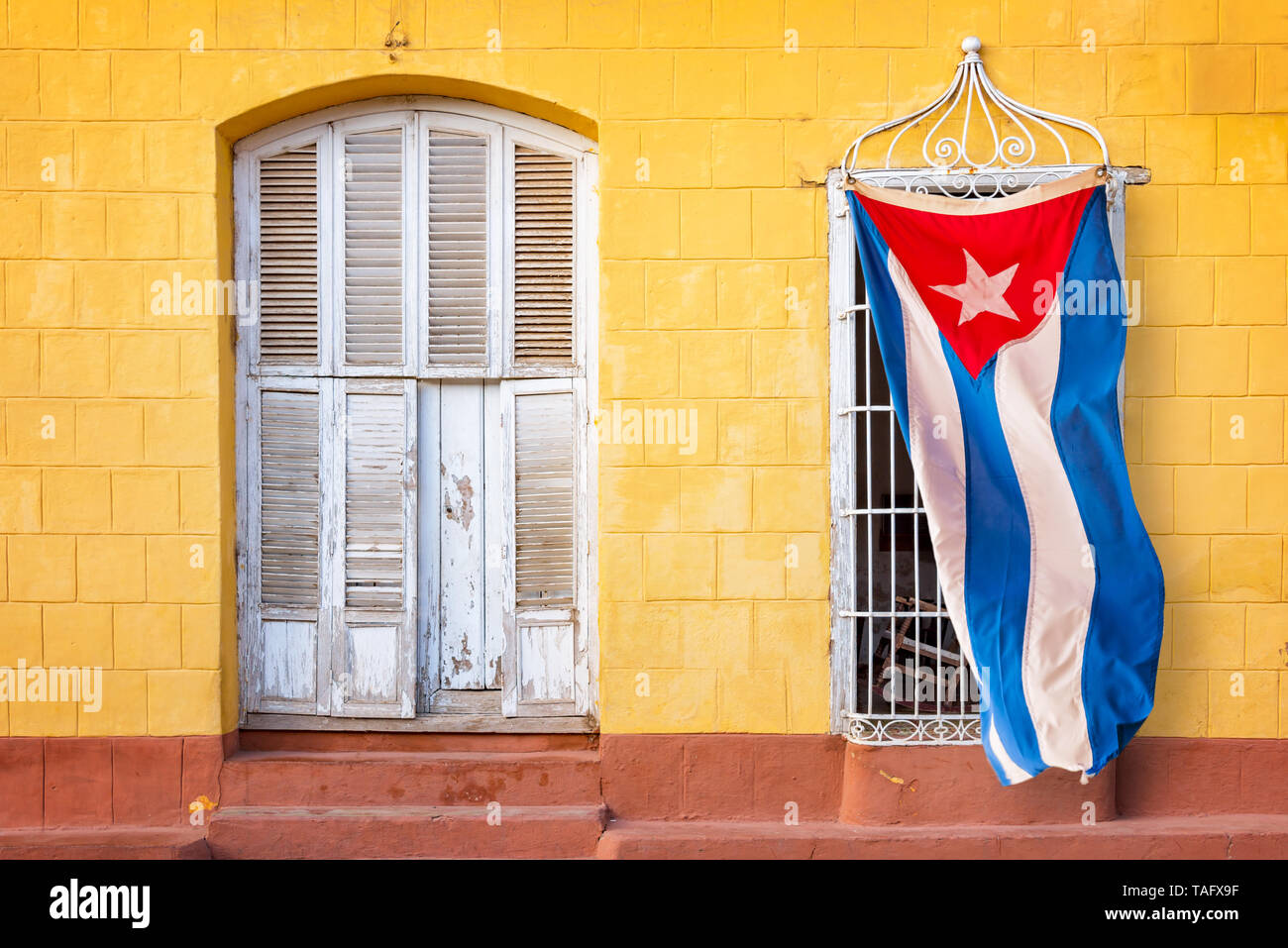 Kubanische Flagge hängen am Fenster eines bunten Haus in einer Straße von Trinidad, Kuba Stockfoto