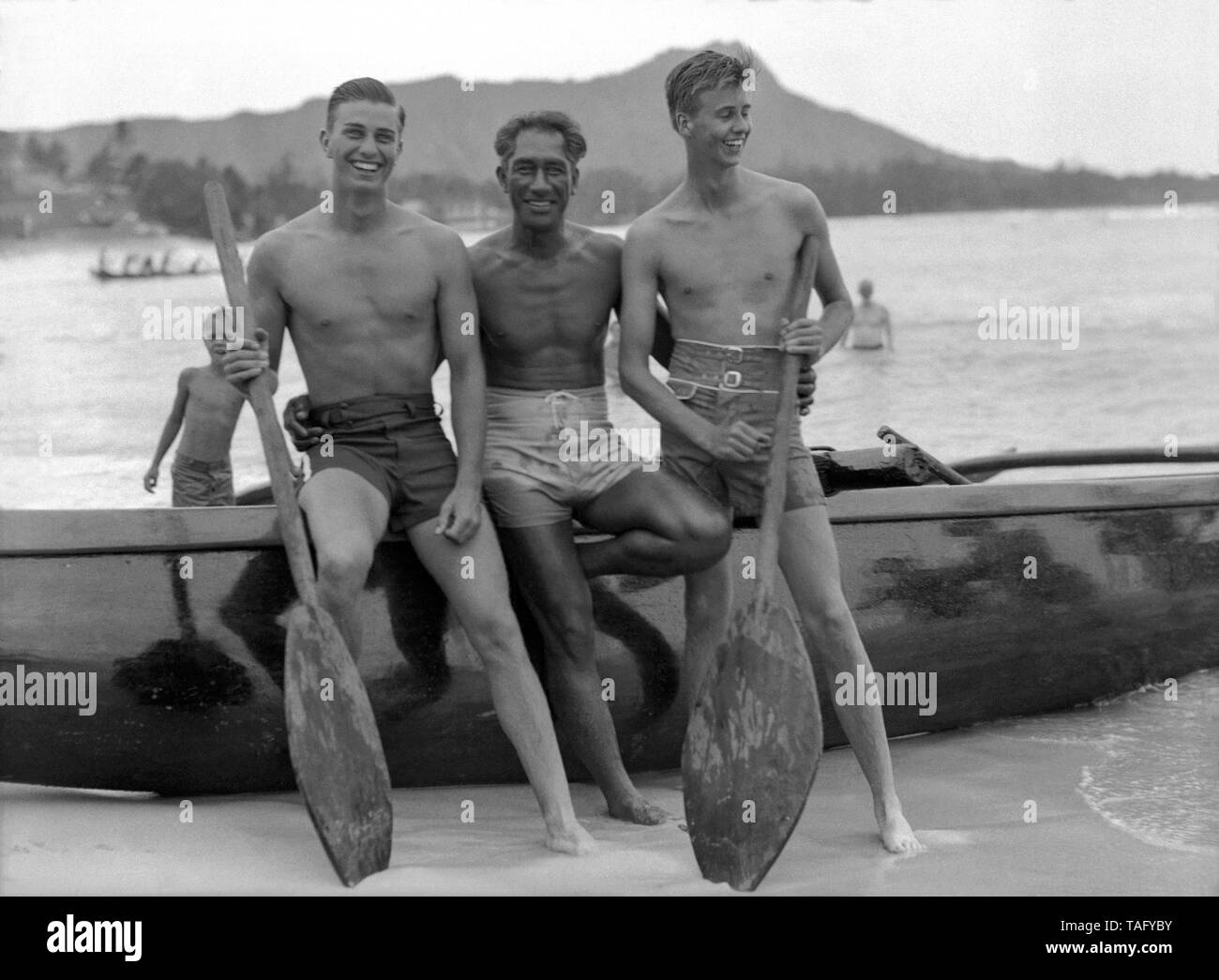 Hawaiian Surf Legende, Duke Kahanamoku, mit FDR Söhne Franklin D. Roosevelt, Jr. und John Roosevelt am Strand von Waikiki in Honolulu, Hawaii. Präsident Roosevelt, zusammen mit seinen Söhnen, reiste an Bord der USS Houston nach Hawaii im Jahr 1934, der der erste Besuch war eines sitzenden US-Präsident für das Gebiet. Duke Kahanamoku gab private Surfen Lektionen an die Roosevelt Söhne und ihre Partei während Ihrem Aufenthalt in Waikiki. Stockfoto