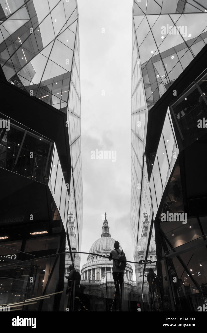 Ein Blick auf die St. Paul's Cathedral Dachkuppel suchen nach zwischen zwei modernen Gebäuden eine neue Änderungen an Shopping person Stockfoto