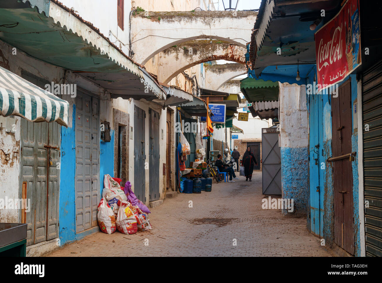 Schmale Straße mit Geschäften und blau und weiß gestrichenen Häusern in der alten Medina von Rabat. Rabat, Marokko. Stockfoto