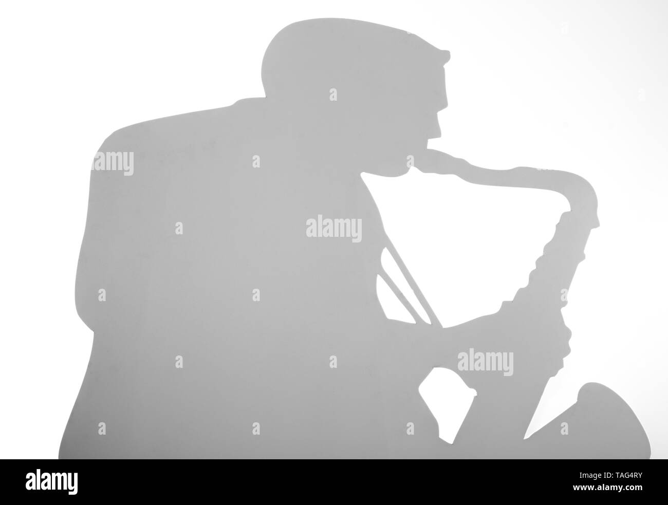 Isolierte Schatten eines Musikers auf weißem Hintergrund im Studio Stockfoto