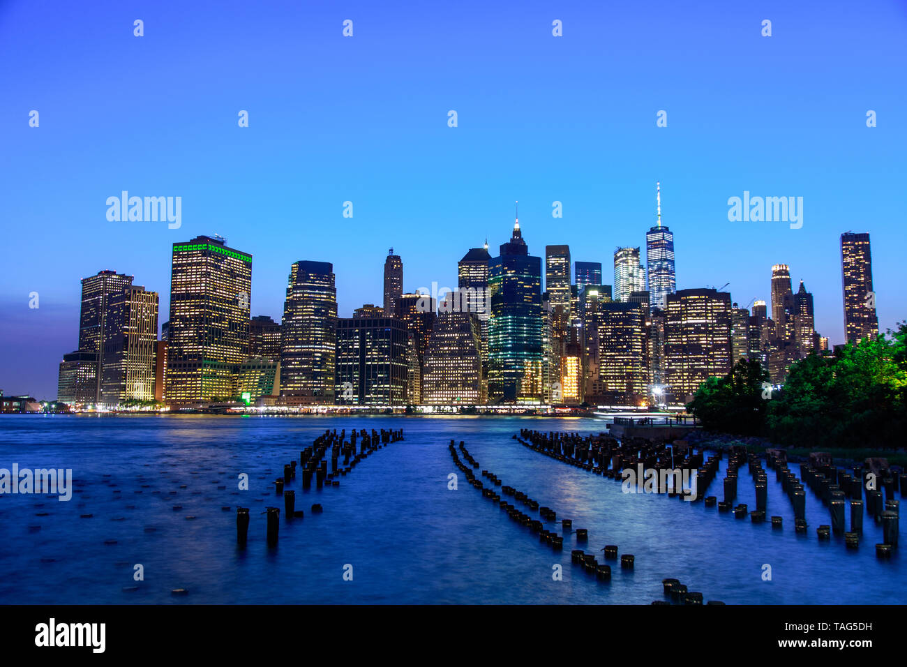 Manhattan in der Abenddämmerung von der Brooklyn Bridge Park in New York City gesehen Stockfoto Manhattan in der Abenddämmerung von der Brooklyn Bridge Park in New York City gesehen Stockfoto