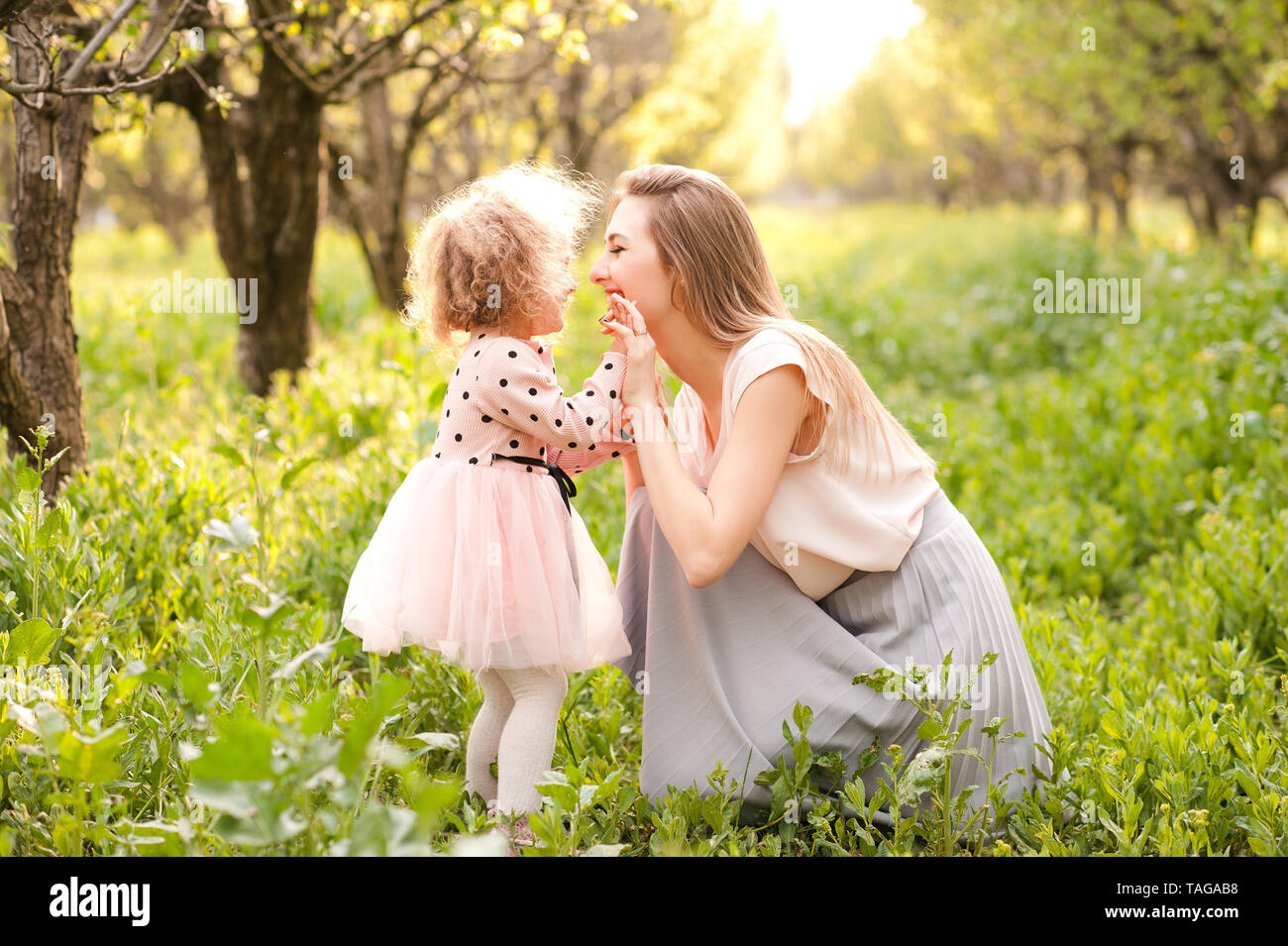 Glückliche Mutter spielt mit Kind Tochter im Freien. Die Mutterschaft. Glück. Stockfoto