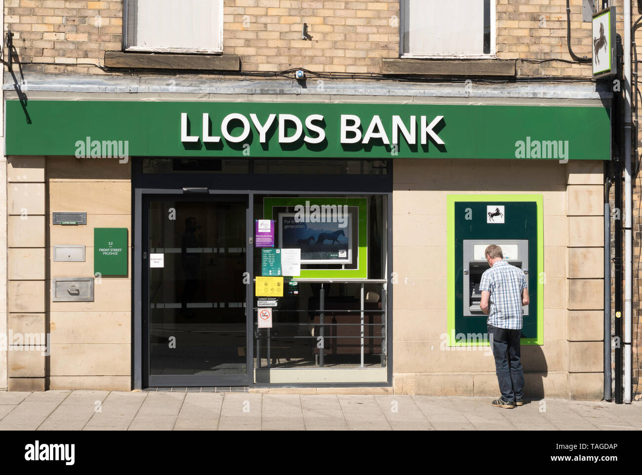 Mann mit einem Geldautomaten bei Lloyds Bank in Prudhoe, Northumberland, Großbritannien Stockfoto