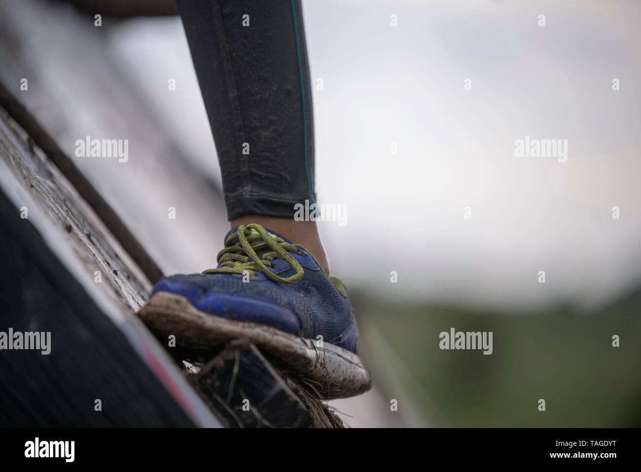SOFIA, Bulgarien - 7. JULI 2018: Ist ein Mädchen Fuß gegen einen nassen schmutzige Wand versucht ein Hindernis in einer Stärke Rennen zu überwinden Stockfoto