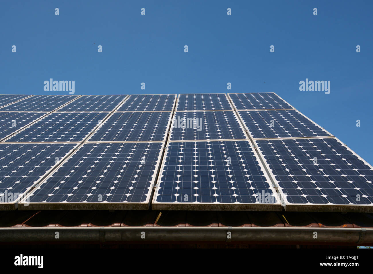 Solar Panel genießen Sie die blauen Himmel Sonne, moderne Solarzellen oder Photovoltaik auf dem Dach eines alten Holzschuppen mit neuen Dachrinne vor dem azurblauen Himmel Stockfoto