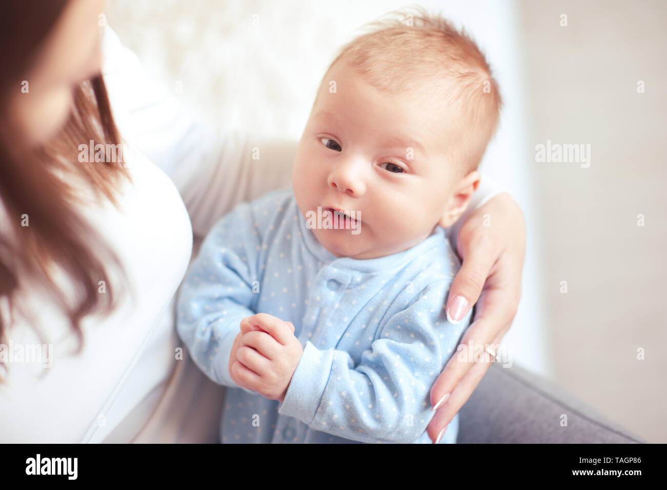 Cute Baby Boy 1-2 jährige liegen auf Mutter Nahaufnahme. Mit Blick auf die Kamera. Die Mutterschaft. Mutterschaft. Stockfoto
