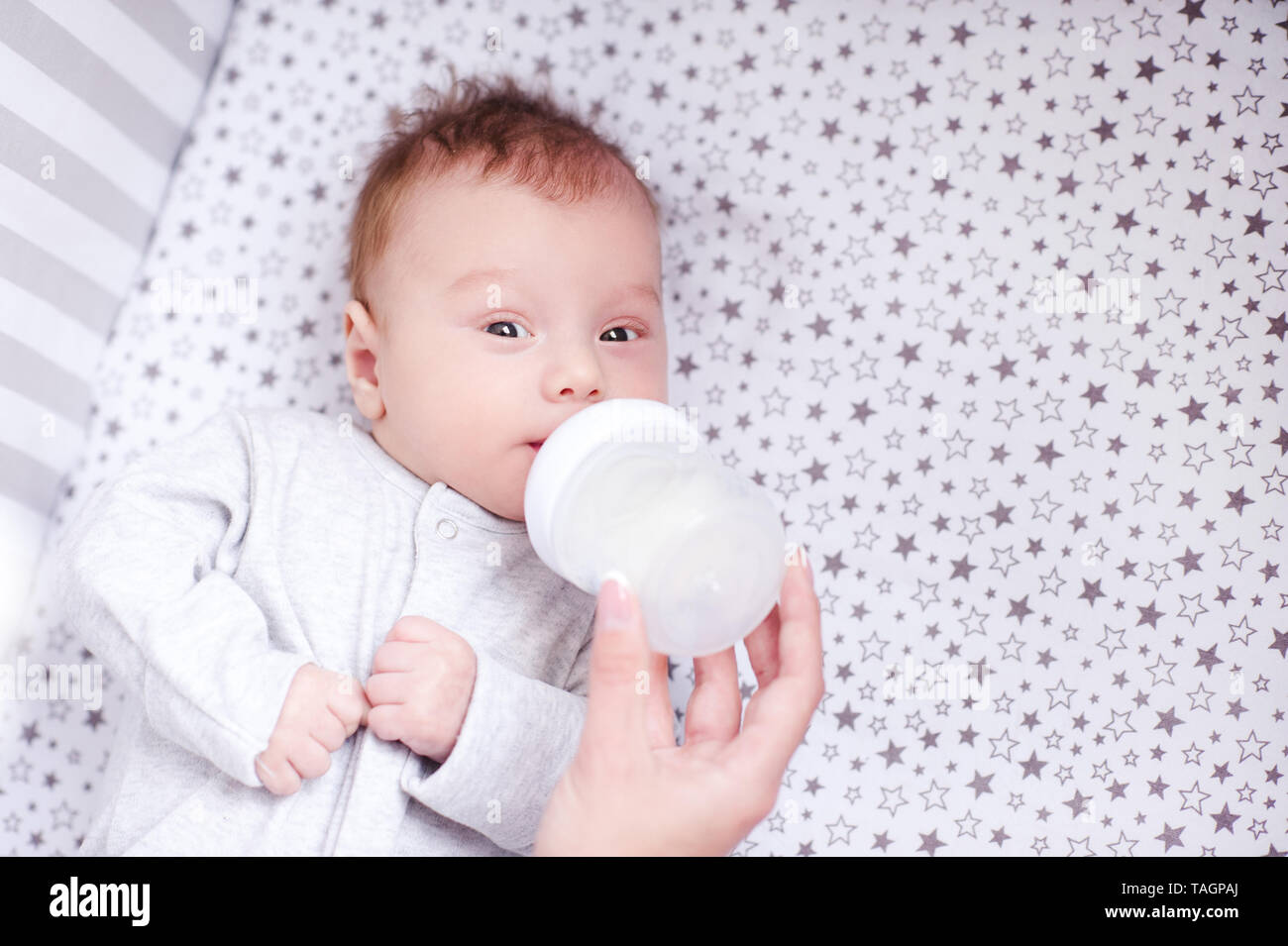 Mutter feeding baby boy mit Milch im Bett. Gesunde Ernährung. Stockfoto