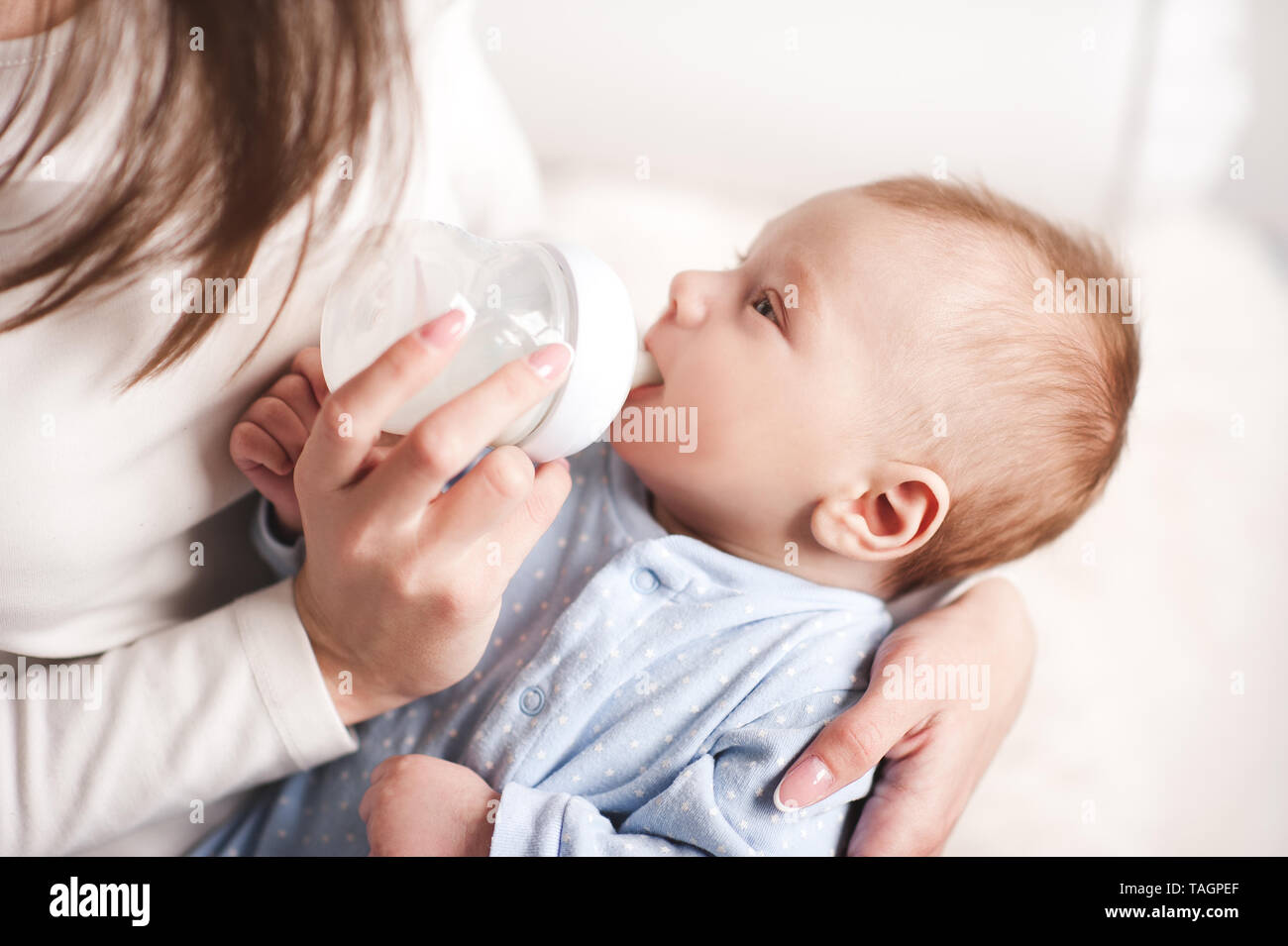 Mutter feeding baby boy mit Milch im Zimmer. Die Mutterschaft. Mutterschaft. Stockfoto
